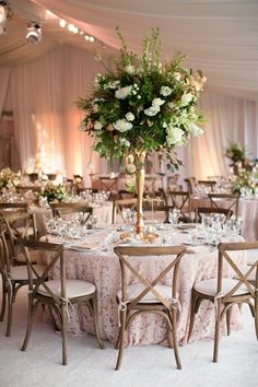 the tables are set with white flowers and place settings