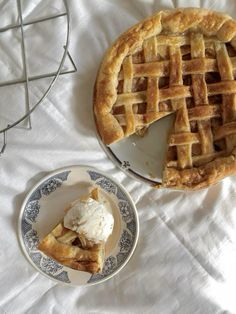 an apple pie with a slice missing from it on a plate next to another pie