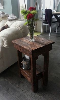 a small wooden table with a vase on top