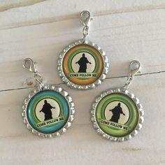 three bottle caps with the words come follow me and a silhouette of a man on them