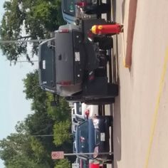 two trucks parked next to each other on the side of a road with trees in the background