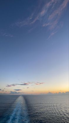 the back end of a boat as it travels through the ocean at sunset or dawn