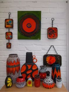 some vases and other decorative items on a table in front of a white brick wall