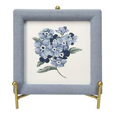 a blue and white flower painted on the side of a small square tray with gold handles