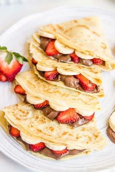 pancakes with chocolate and strawberries on a white plate