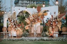 an outdoor wedding setup with chairs and flowers