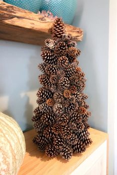 a pine cone christmas tree sitting on top of a wooden shelf