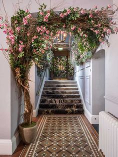 the stairs are lined with pink flowers and greenery