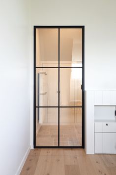 an empty room with wooden floors and glass doors