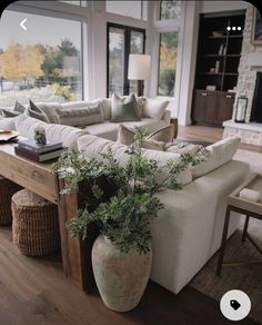 a living room filled with furniture and a large window covered in lots of natural light