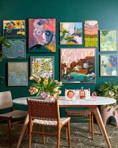 a dining room with green walls and pictures on the wall