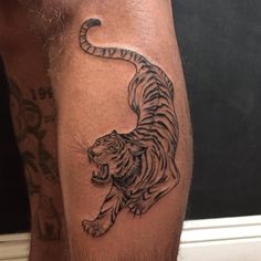 a man with a tiger tattoo on his leg