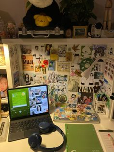 an open laptop computer sitting on top of a white desk next to a stuffed animal