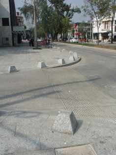 there are several cement blocks on the street and one is empty with people walking around