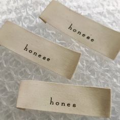 three pieces of cloth that say honey, honee, and bones on them with words written in black ink