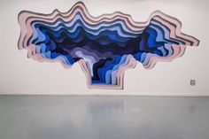 an abstract painting on the wall with blue and pink shapes in it's center