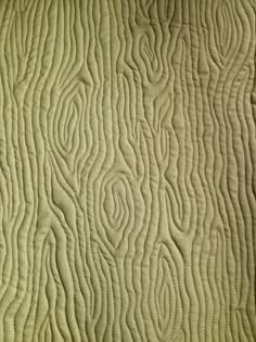 a close up view of a quilted material with wavy lines and curves on it