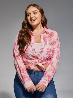 a woman in jeans and a pink shirt is posing for the camera with her hands on her hips