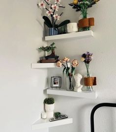 three white shelves with flowers and pictures on them