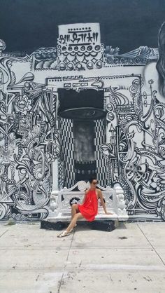 a woman in a red dress sitting on a bench