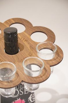 four shot glasses are placed in front of a bottle with an empty glass on it