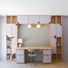 a room with some shelves and a desk in front of a wall mounted bookcase