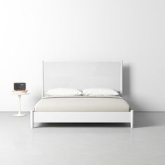 a white bed sitting next to a night stand