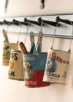 several tins hanging from hooks on a wall