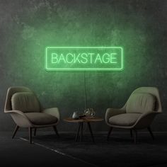 two chairs and a table in front of a green wall with the words backstage on it