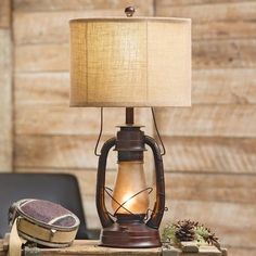 a lamp sitting on top of a wooden table next to a chair and suitcases