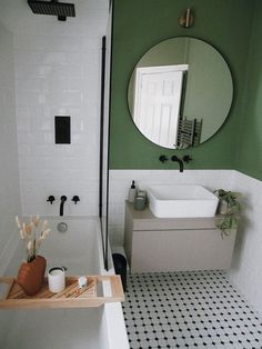 a bathroom with a sink, mirror and bathtub in the middle of the room