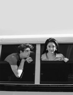 two people looking out the window of a bus