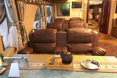 a living room with recliners, chairs and a table in front of it