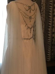 a white wedding gown on display in front of a window