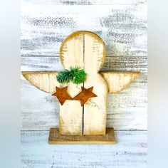 a wooden figure with two brown stars and a green plant on it's back