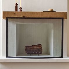 a piece of wood sitting inside of a glass case on top of a fireplace mantel