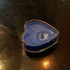 a heart shaped container sitting on top of a metal table next to a light bulb