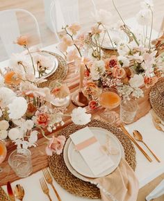 the table is set with flowers and place settings