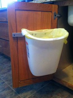 a trash can is sitting in the cabinet