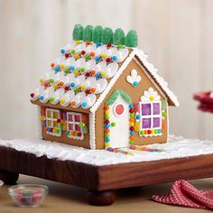 a gingerbread house decorated with icing and sprinkles on a table