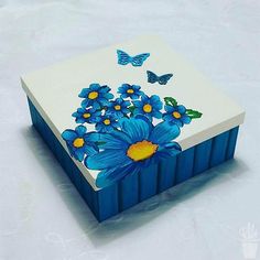 a painted box with blue flowers and butterflies on it