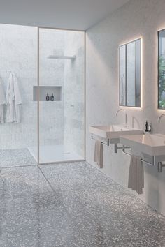 a bathroom with two sinks and a walk in shower