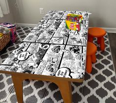 the table is covered with comic books and orange stools in front of it on a patterned rug