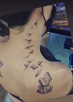 a woman with a book and flying birds tattoo on her back