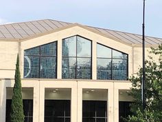 a large building with many windows and trees in front of it