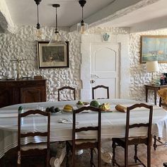 a dining room table and chairs in front of a white wall