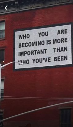 a sign on the side of a building that says, who you are becoming is more important than ho you've been