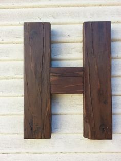 a wooden object is hanging on the side of a white building with wood slats