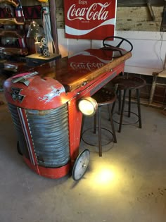 an old coca - cola machine is sitting in the garage