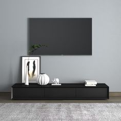 a black entertainment center with a large flat screen tv mounted on it's wall